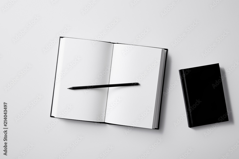 top view of black notebooks with pencil on white surface for mockup top view of black notebooks with pencil on white surface for mockup
