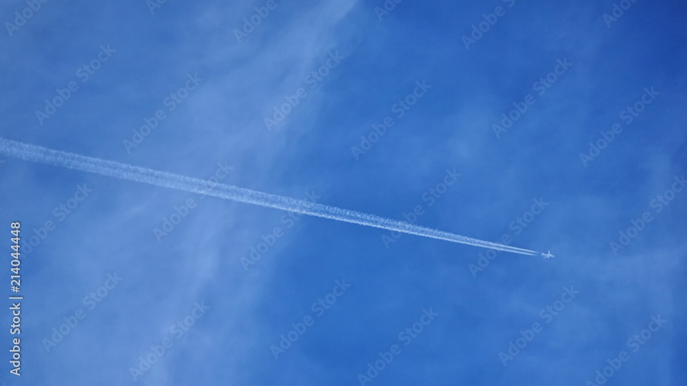 Plane with trail and blue sky Plane with trail and blue sky