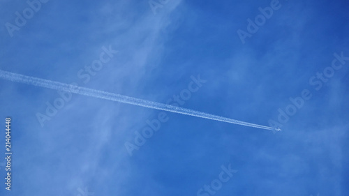Plane with trail and blue sky