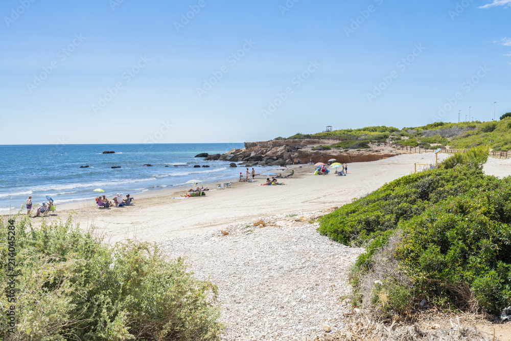 Tourist on the beach on a sunny day. Mediterranean coast, sea. Alcossebre, Valencia Spain. 