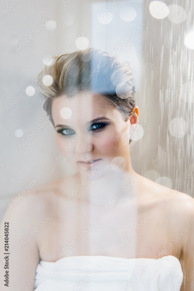 Beautiful sexy young woman washing body in a shower blurred behind the glass Beautiful sexy young woman washing body in a shower blurred behind the glass
