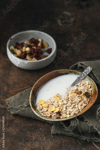 Healthy breakfast. Fresh granola, muesli with yogurt, nuts and dried berries on rustic background.  © Max D. Photography