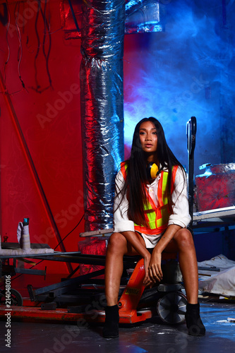 Beautiful Asian Architect Engineer woman long straight Hair, safety vast short pant. Concept woman can do destruction construction site area room sit on Hand pallet truck, fashion red blue color wall
