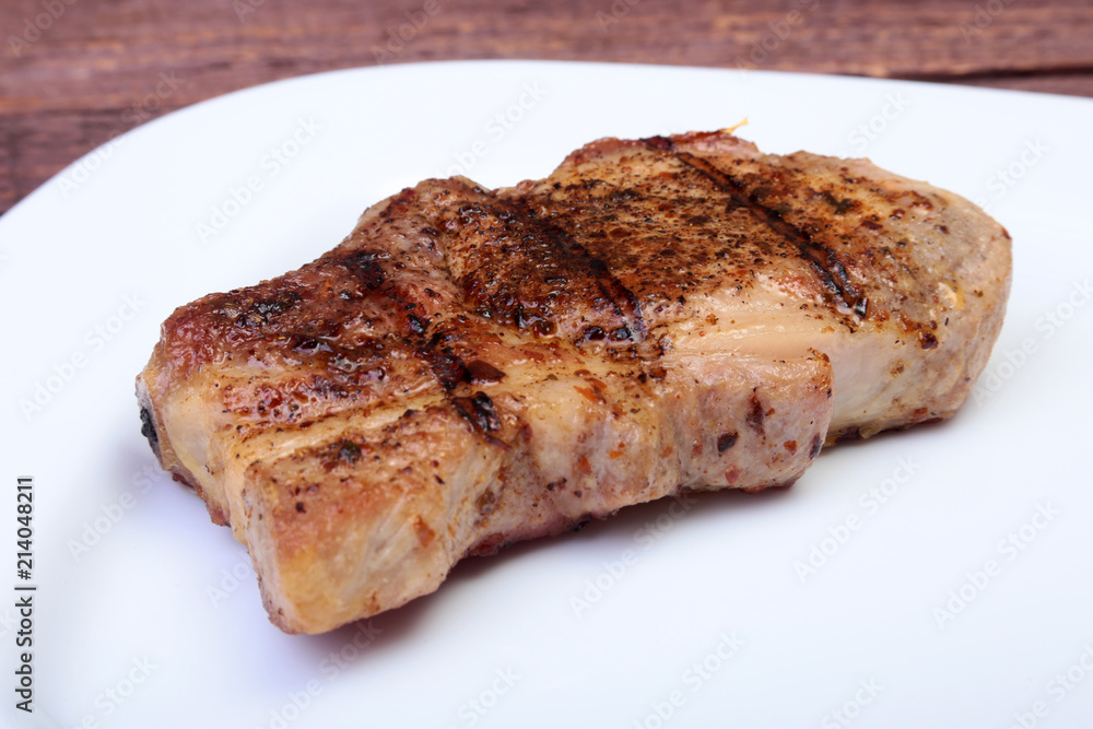 grilled pork chop on plate on wooden board grilled pork chop on plate on wooden board