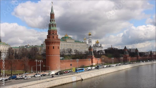 Russia, Moscow, center - view from the Big stone bridge on the Kremlin wall, the Church with Golden domes, towers of red square, traffic on the Kremlin quay in the spring against the cloudy sky