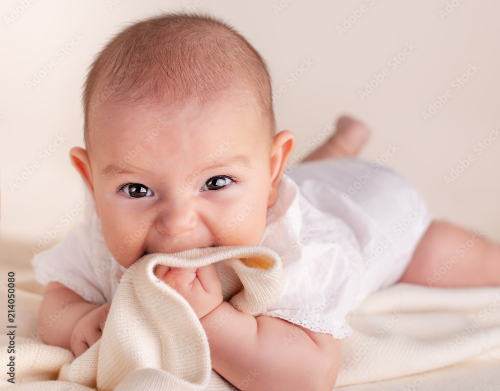 Small cute funny baby infant teething with face expression hands and fingers in mouth Small cute funny baby infant teething with face expression hands and fingers in mouth
