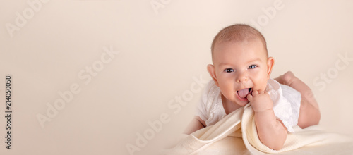 Fotografie, Obraz Small cute funny baby infant smiling happily and fingers in mouth sore