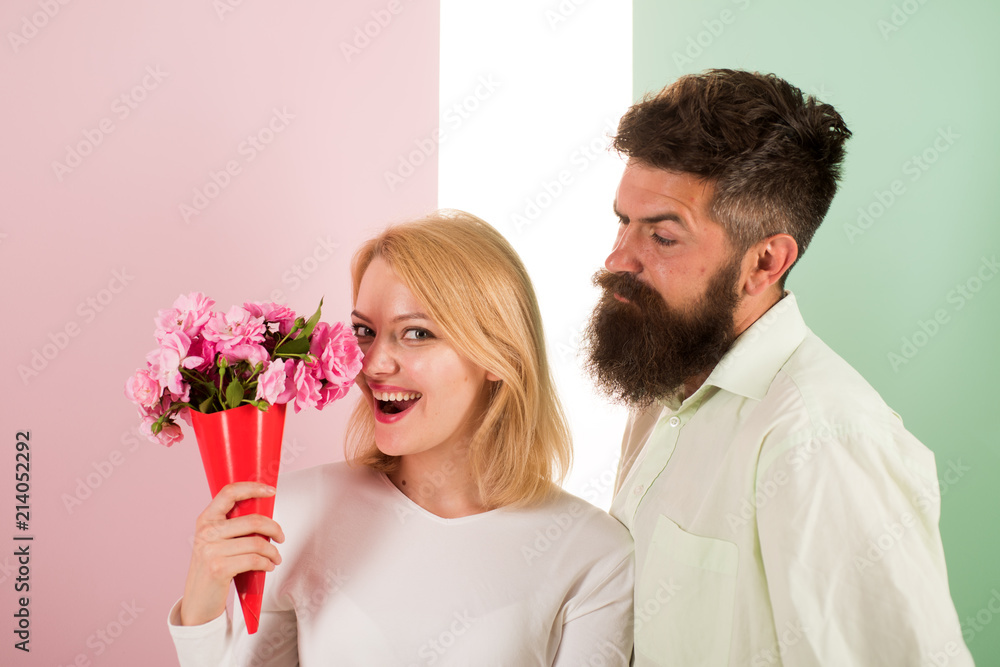 Woman enjoy fragrance bouquet flowers. Man with beard takes care about girlfriend happiness. Lady likes flower husband gifted her. Flowers delivery concept. Couple in love happy celebrate anniversary Woman enjoy fragrance bouquet flowers. Man with beard takes care about girlfriend happiness. Lady likes flower husband gifted her. Flowers delivery concept. Couple in love happy celebrate anniversary