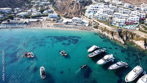 Aerial drone photo of famous pool resorts on top of rocky emerald seascape in iconic island of Mykonos, Psarou beach near Platy Gialos, Cyclades, Greece photo