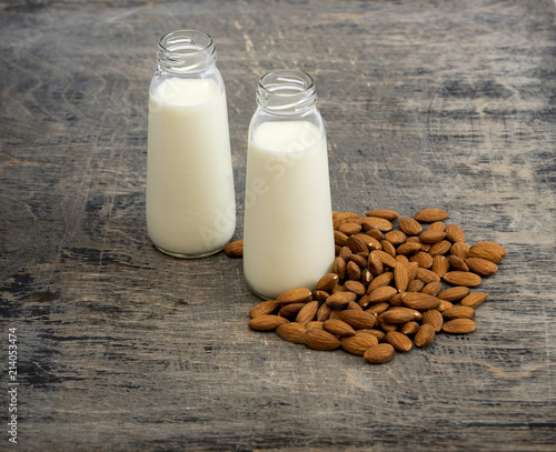 Almond milk in small bottles and almonds