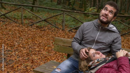 romantic couple on a bench looks at the autumn sky photo