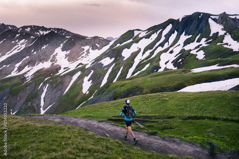 Fototapeta premium A trail runner running through the mountains at sunset