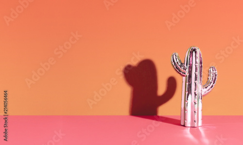 Creative golden cactus on orange background.