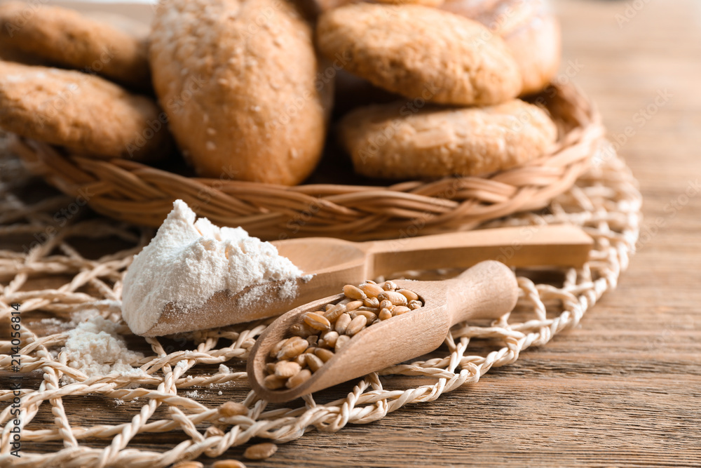 Scoops with flour and wheat grains on wooden table. Baking ingredients Scoops with flour and wheat grains on wooden table. Baking ingredients