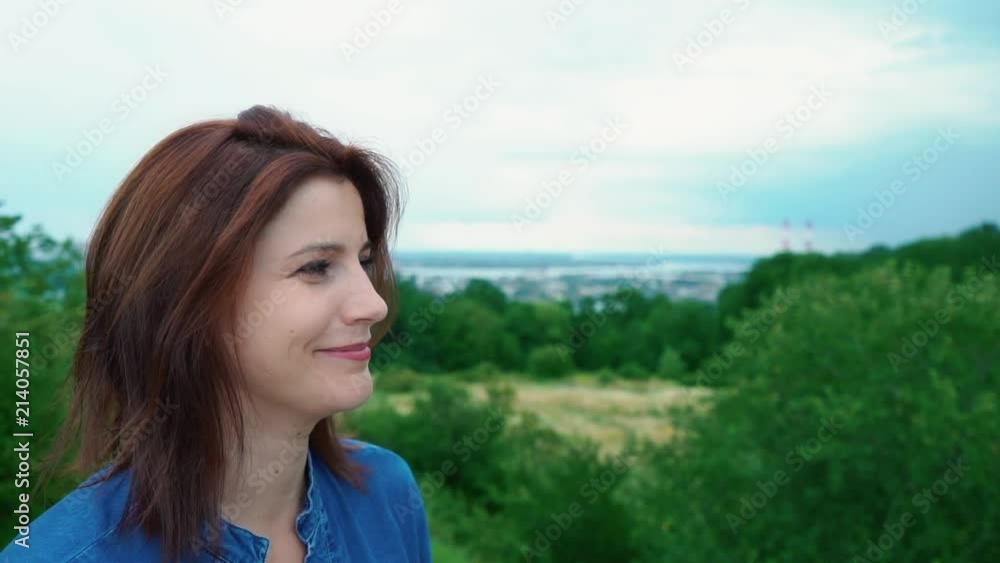 Profile of a smiling girl on a nature background. Portrait of a young red-haired woman staring into the distance with a smile on her face Profile of a smiling girl on a nature background. Portrait of a young red-haired woman staring into the distance with a smile on her face
