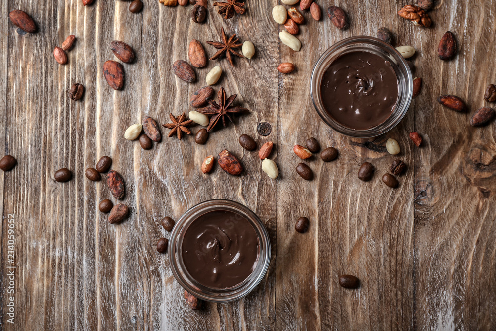 Bowls with molten chocolate with nuts and beans on wooden table Bowls with molten chocolate with nuts and beans on wooden table