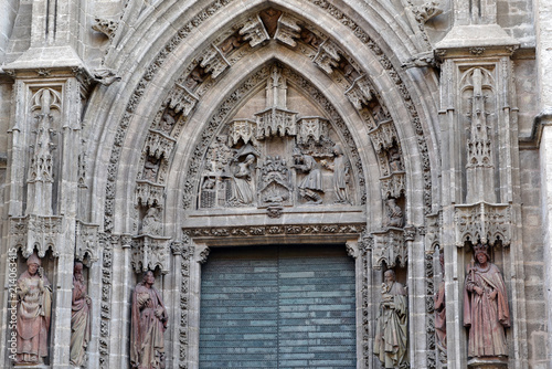 Beautiful carved bas-relief and green door of Assumption, Sevilla Cathedral, Spain