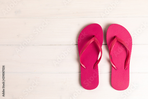 pink flip flops on white wooden background with copy space