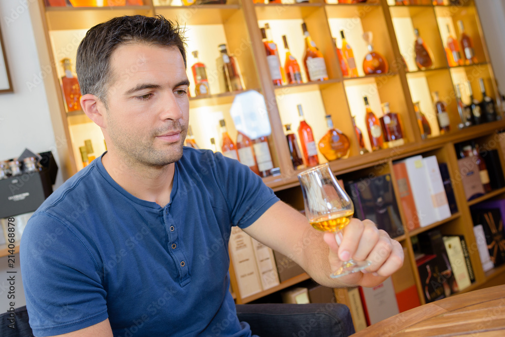 Man having taster in distillery shop