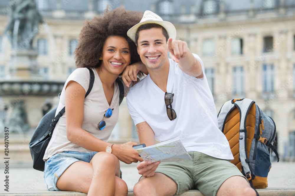 Obraz premium young tourists pointing at a sight in the city