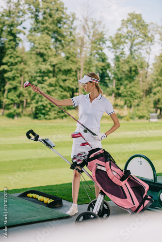 female golf player in cap with golf gear at golf course