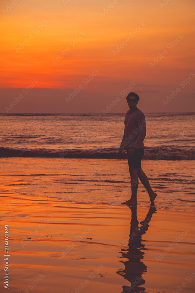 Man enjoying on the ocean beach in sunset / sunrise time.