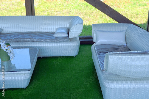 Rattan table and chaise longues near modern swimming pool, closeup photo