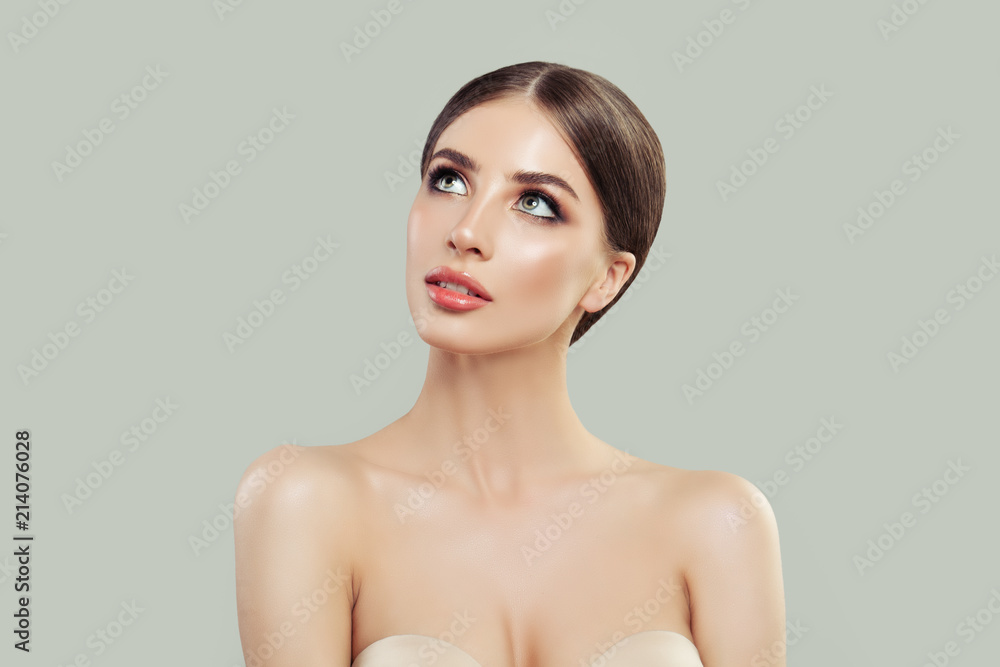 Young woman looking up on background with copy space. Beautiful model with healthy skin. Facial treatment, skincare, cosmetology, beauty and spa Young woman looking up on background with copy space. Beautiful model with healthy skin. Facial treatment, skincare, cosmetology, beauty and spa