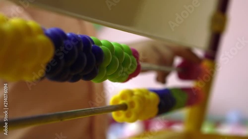 Baby counting on abacus playing game in daycare with financial tools, elementary education Close up photo