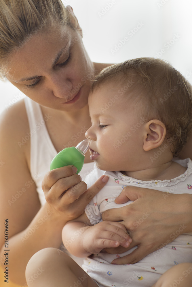 mother cleaning babies nose. vacuum pump mother cleaning babies nose. vacuum pump