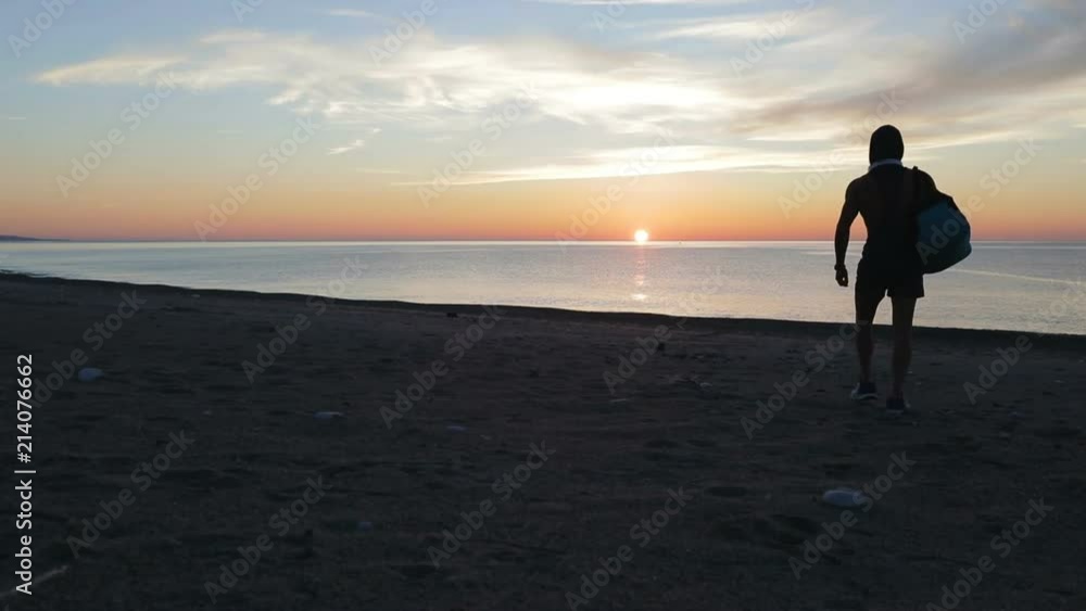 Silhouette di un ragazzo si sta allenando di fronte l'Oceano o il mare all'alba di mattina presto. Silhouette di un ragazzo si sta allenando di fronte l'Oceano o il mare all'alba di mattina presto.