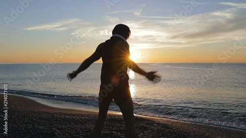 Silhouette di un ragazzo si sta allenando di fronte l'Oceano o il mare all'alba di mattina presto. photo