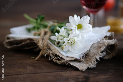 chamomiles in napkin on old rustic wooden table