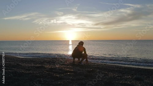 Silhouette di un ragazzo si sta allenando di fronte l'Oceano o il mare all'alba di mattina presto. photo