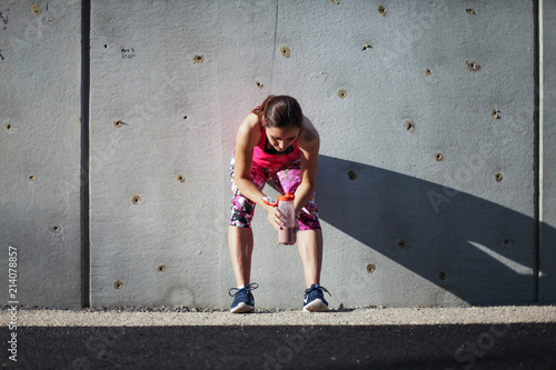 tired resting sports woman almost knockout after workout drinking a healthy shake from a bottle outdoors 