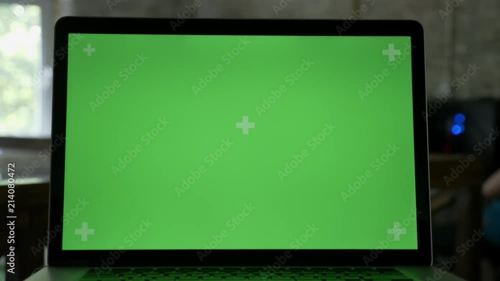 Close moving shot of laptop's display with chromakey in modern office Close moving shot of laptop's display with chromakey in modern office