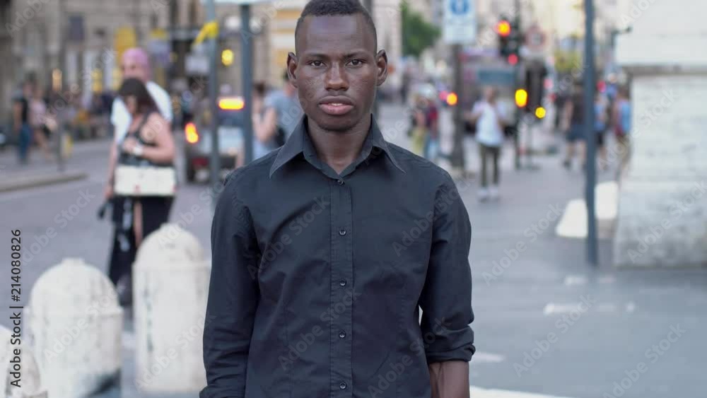 Young american african man crossing his arms in the street- slow motion Young american african man crossing his arms in the street- slow motion