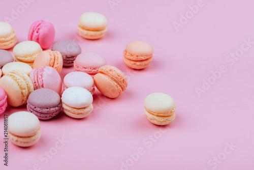 Different types of macaroons on pink background.