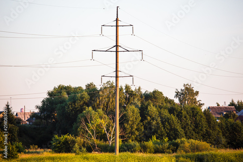 Electric pole in the rays of sunset in nature photo