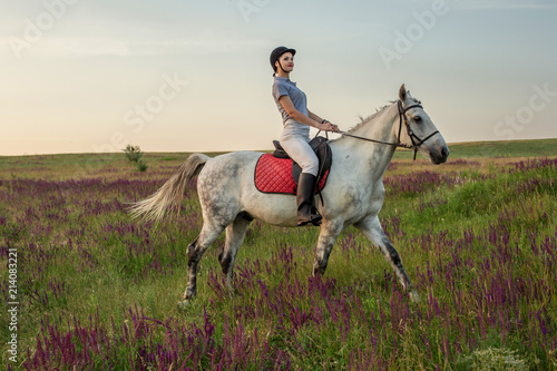 Horsewoman jockey in uniform riding horse outdoors © nazarovsergey
