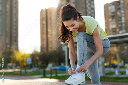 Slika na platnu Young woman tying sports shoe