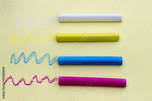 Multicolored crayons on yellow background, isolated