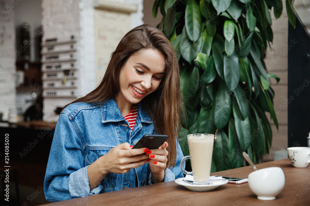 Young woman texting or using smartphone and drinking coffee Young woman texting or using smartphone and drinking coffee