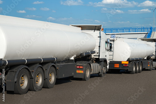 white tank trucks on the road, clear space on the cistern side, oil transportation concept