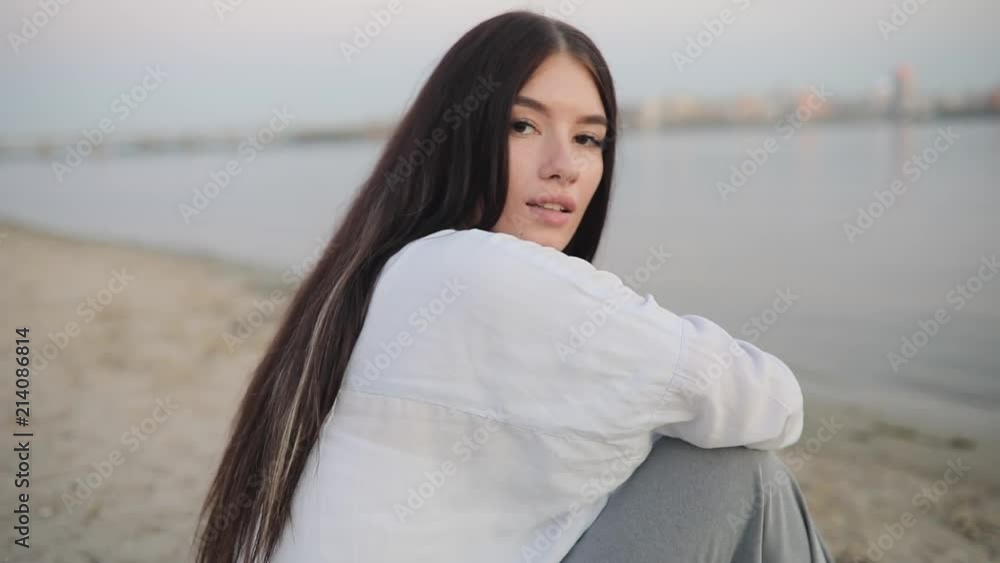 Cute young woman portrait sitting at river beach Cute young woman portrait sitting at river beach
