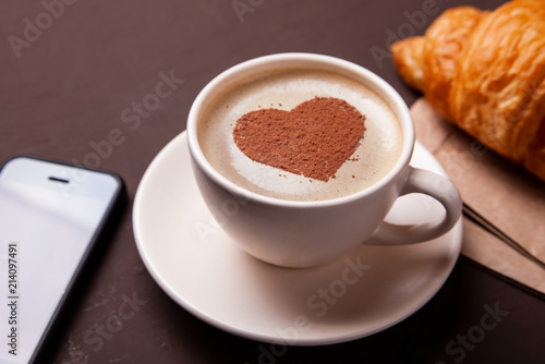 Cup of coffee with heart on the foam. I like to coffee break with croissant
