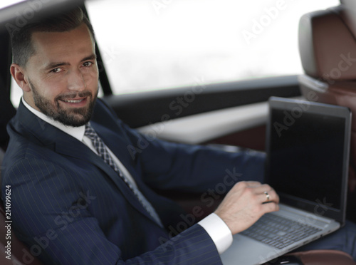 Close-up of a businessman with a laptop sitting in the car © ASDF