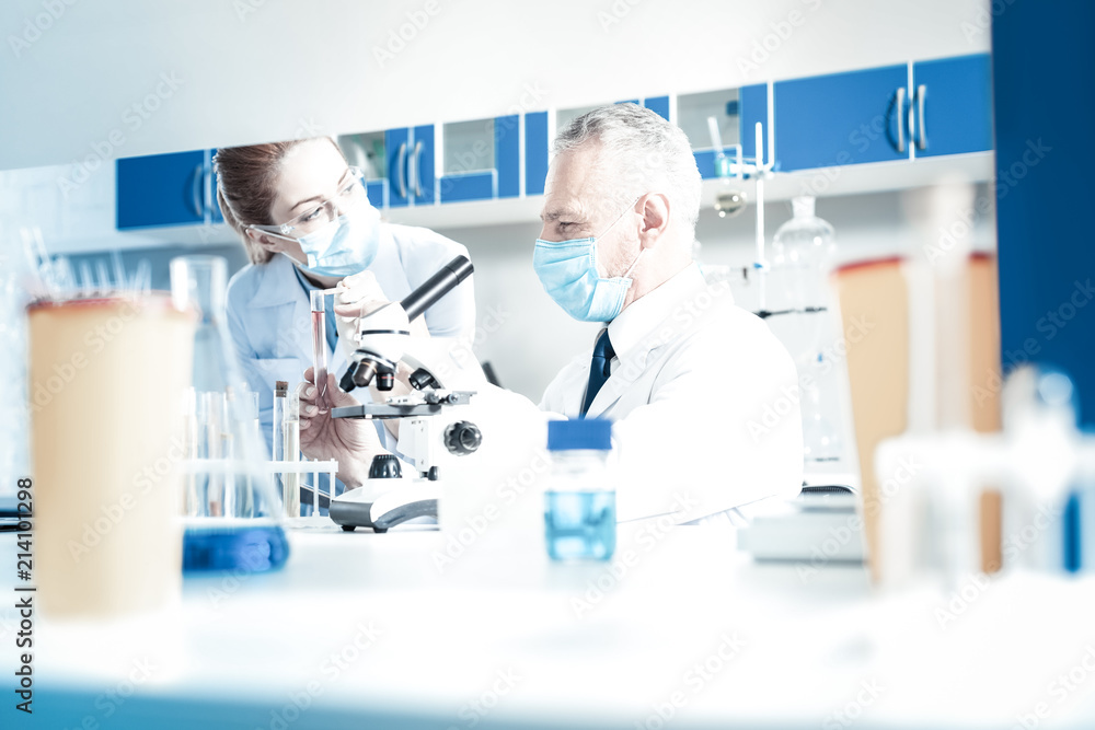 Pleasant cooperation. Joyful positive smart scientists looking at each other and smiling while enjoying working in team Pleasant cooperation. Joyful positive smart scientists looking at each other and smiling while enjoying working in team