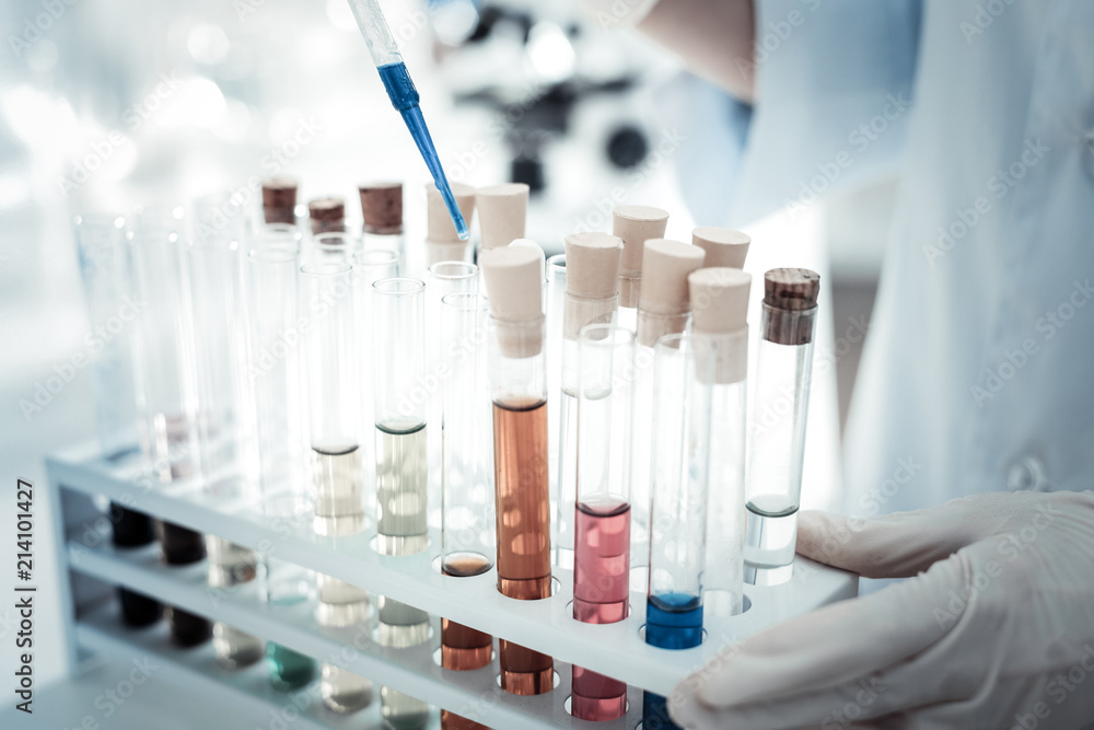 At the medical lab. Close up of test tubes standing in the special rack while being used for medical analysis At the medical lab. Close up of test tubes standing in the special rack while being used for medical analysis