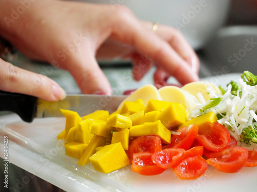 Closeup of hands of chef cook cutting vegetables